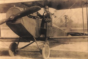 Bessie Coleman, the first African American licensed pilot shown here on the wheel of a Curtiss JN-4 "Jennie" in her custom designed flying suit (circa 1924).